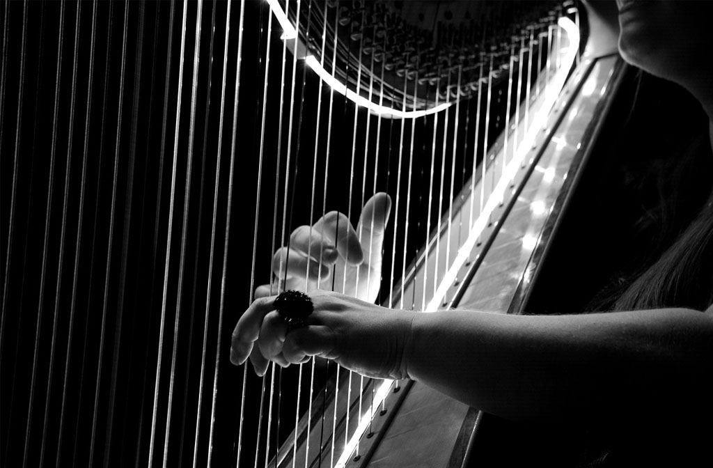 A black and white photo of a harpist