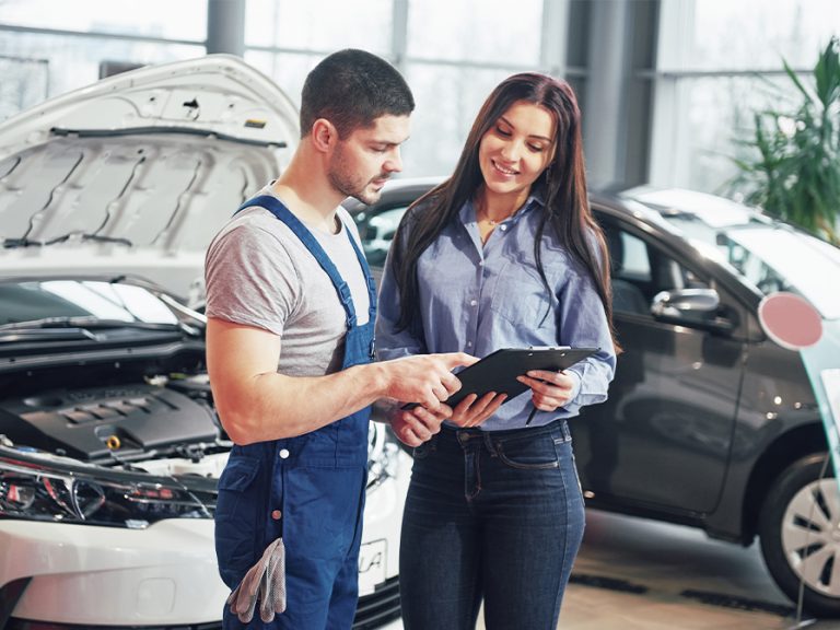 A man mechanic and woman customer discussing repairs done to her vehicle. Image: Standret/Freepik