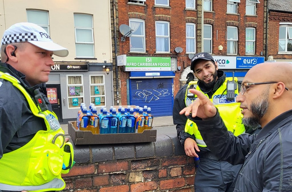 A member of the Queen's Park community speaks with Bedfordshire Police officers after threats of fascist protests. Image: Islam Bedford/Facebook