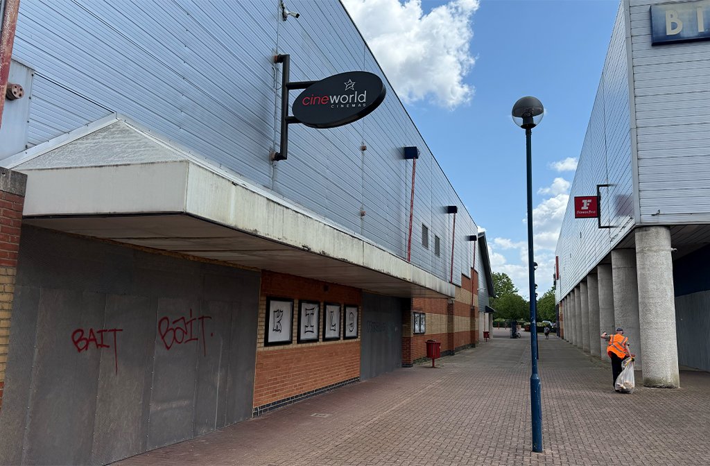 Aspects Leisure Park looking empty and unloved with Cineworld in the foreground. A worker in a high-vis jacket is picking up litter. Image: Bedford Independent