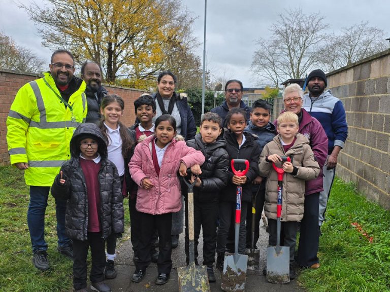 Bedford Borough Labour councillors in Caldwell ward with children and volunteers. They are holding spades and dressed in warm coats after planting some spring bulbs in the community.