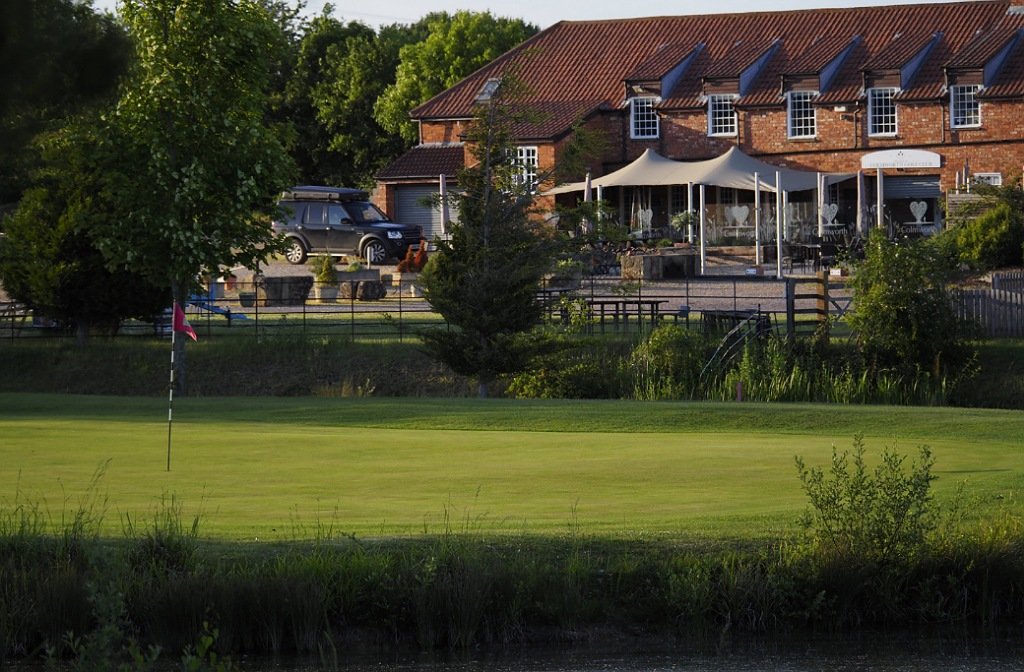The 18th green at Colmworth Golf Club with clubhouse in the background