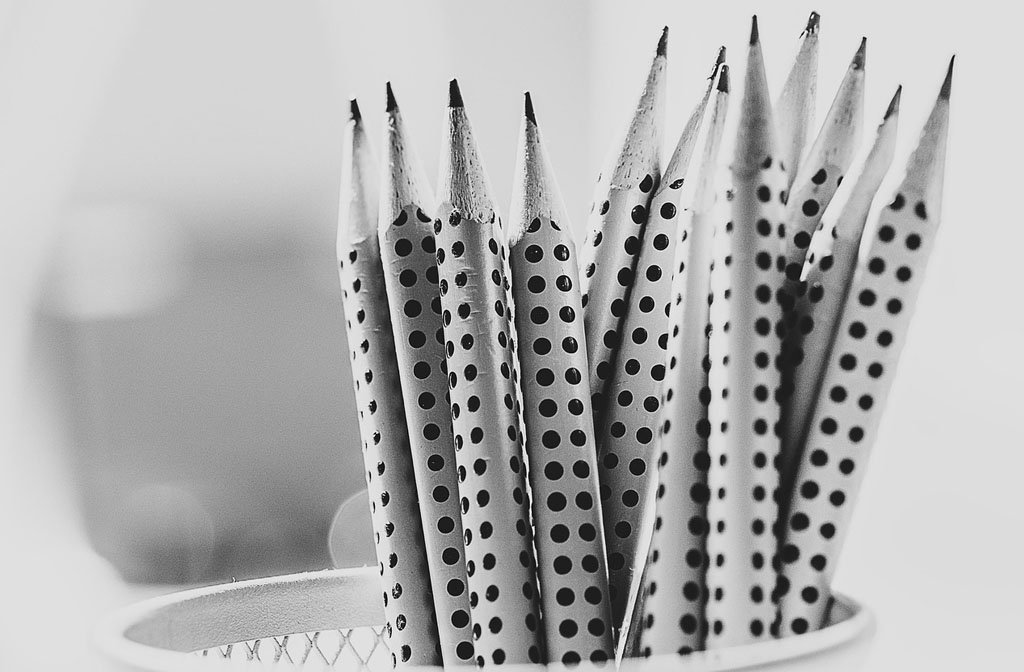 A black and white photograph of a pot of sharpened pencils