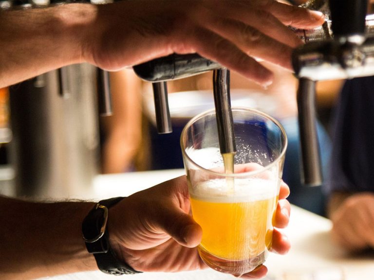 Draft beer being poured into a pint glass.