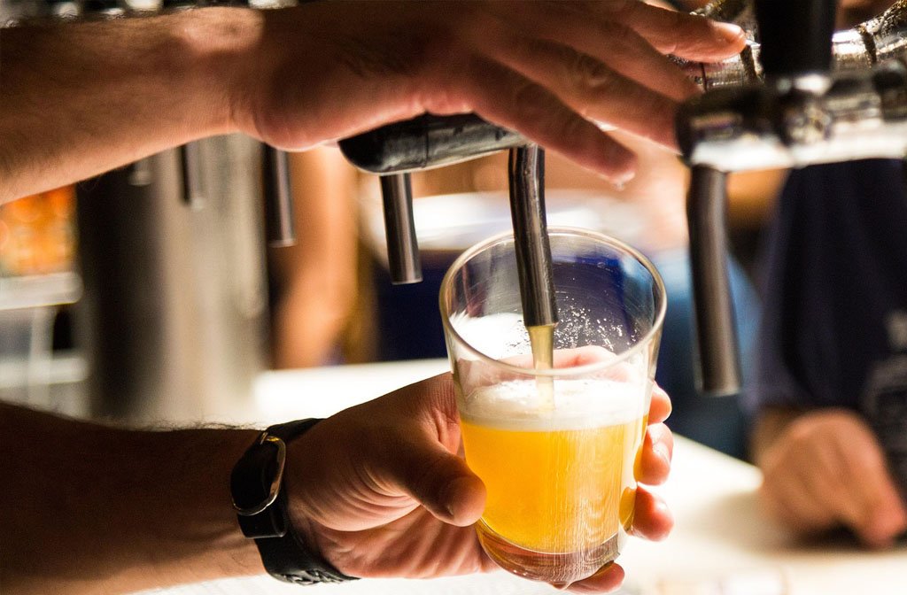Draft beer being poured into a pint glass.