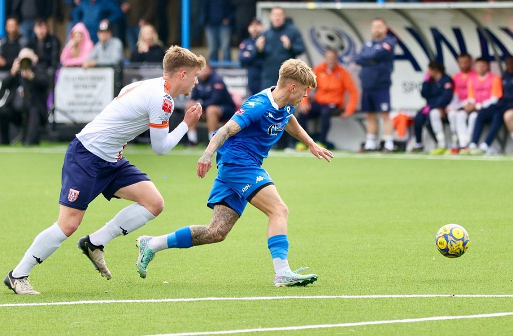 Bedford Town's Eddie Panter holds off a Stratford Town defender