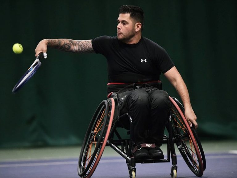 Wheelchair tennis player, Gary Cox hits a shot at an LTA event