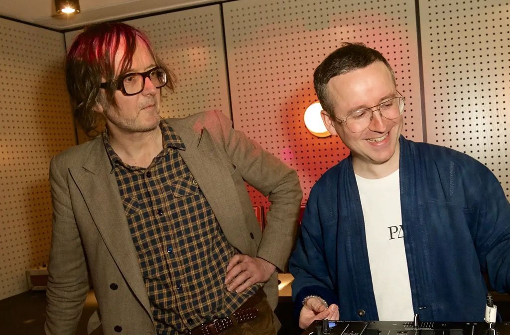 Pulp lead singer, Jarvis Cocker and Alexis Taylor of Hot Chip stand over a mixing desk.
