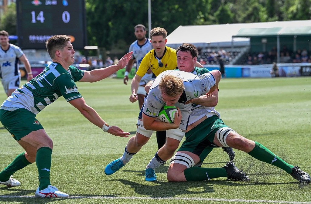 Bedford Blues rugby player Joe Howard crashes through a tackle to score a try for Bedford Blues