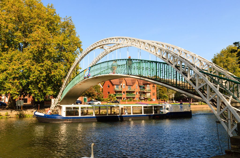 The John Bunyan Boat passing under the Suspension Bridge on the River Great Ouse, Bedford. Image: John Bunyan Community Boat