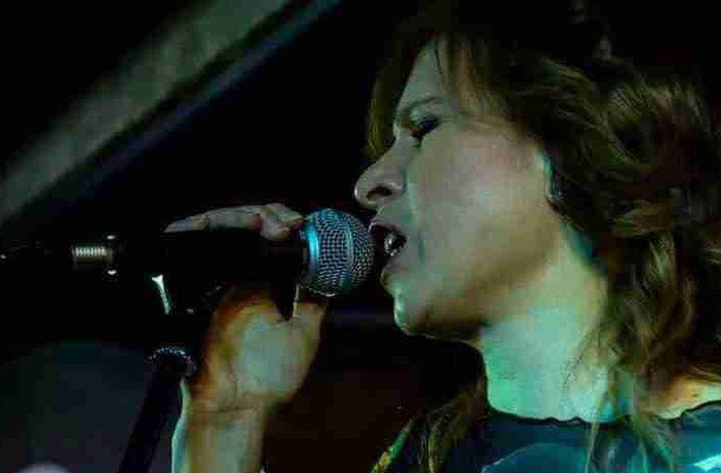 Kyri Lillington singing into a microphone