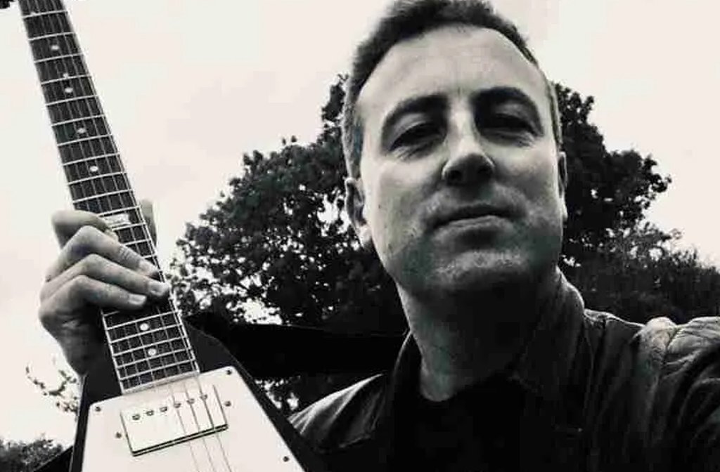 Musician Mat Roberts holding a guitar