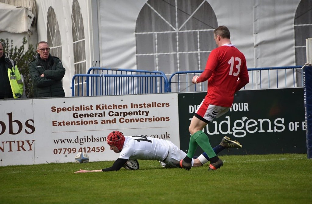 Max Thorne is diving over the try line to score a try for England at Goldington Road