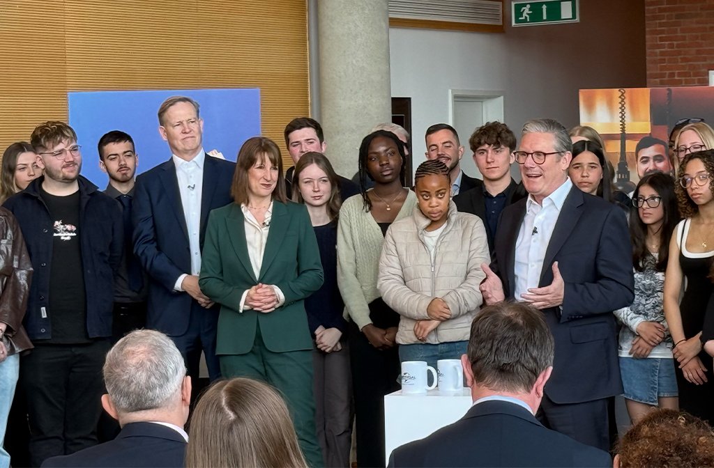 Prime Minister Keir Starmer speaking at Kimberley College about Universal Studios UK looked on by students at the college, Comcast president Michael J. Cavanagh and the Chancellor.