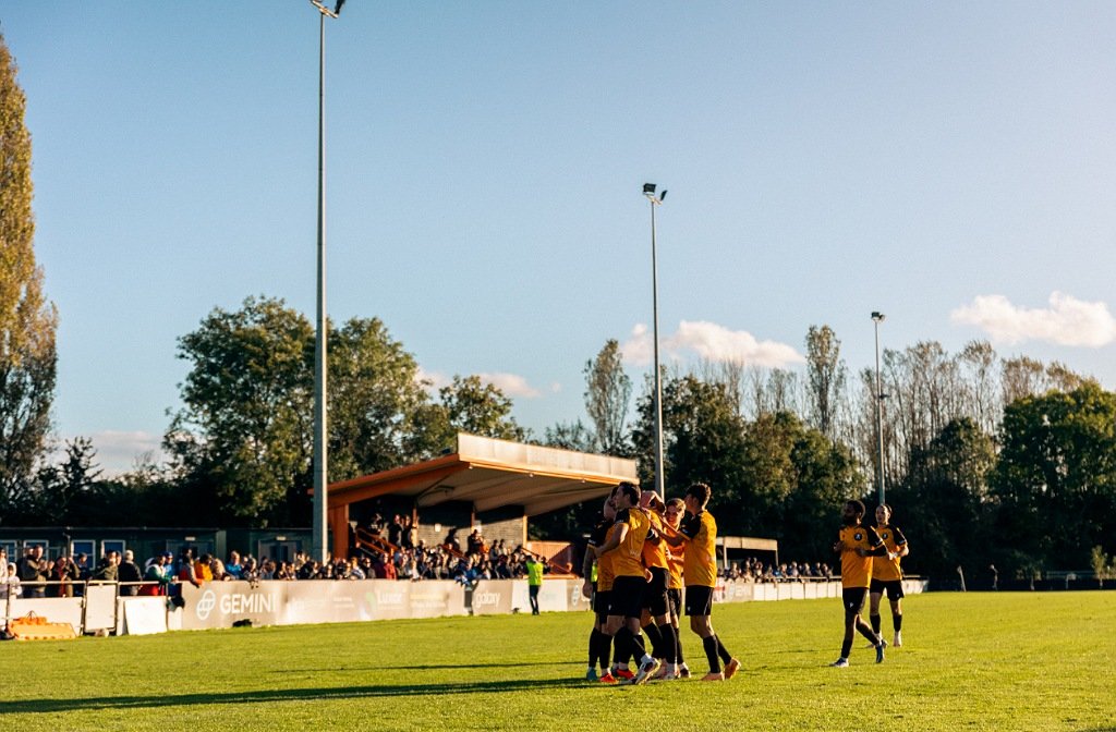 Members of Real Bedford football team celebrating at their McMullen Park ground.