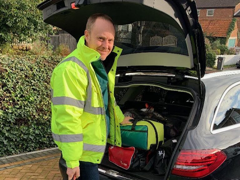 Dave Sharples who attended the 1,000th call out. Wearing his hi-vis jacket and standing near to his car.
