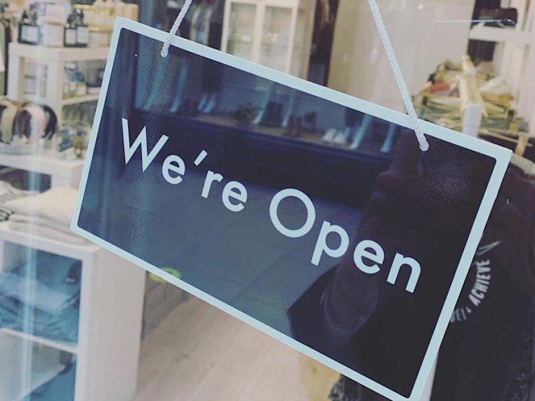 A sign in a shop window saying 'We're Open'