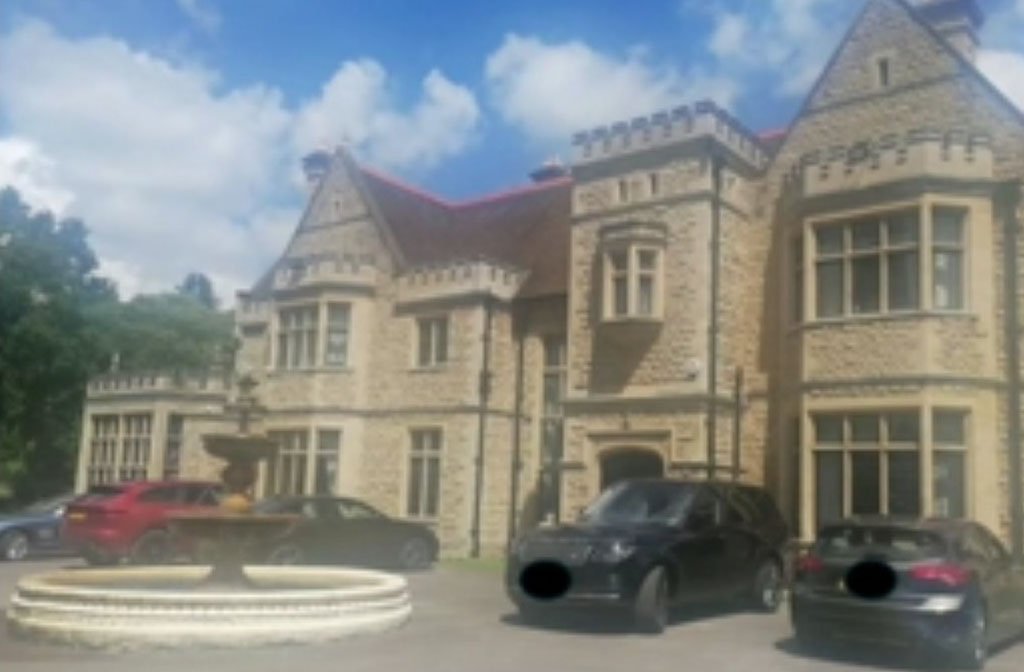 A large manor house in Bromham with an ornamental fountain in the front drive and several high performance cars parked outside. Image: LDRS