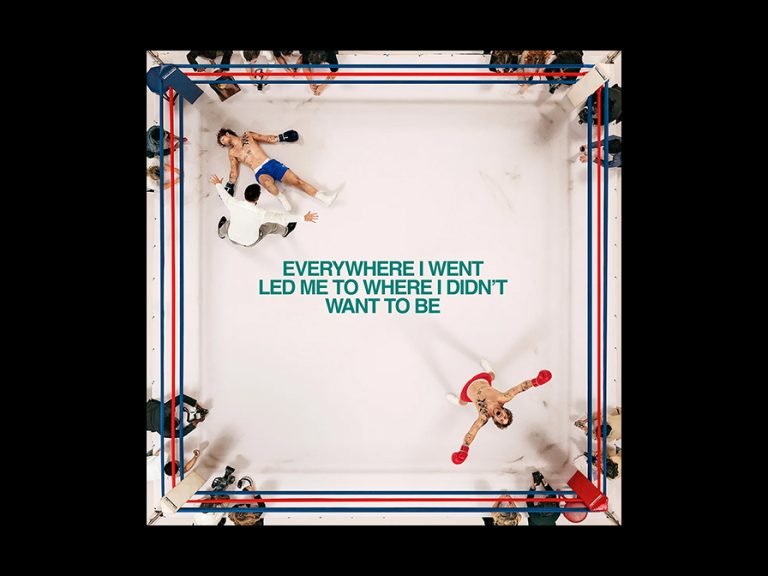 Tom Grennan's fourth album 'Everywhere I Went Led Me To Where I Didn’t Want To Be' album cover shows a boxing ring from above. Tom in red is celebrating winning as his opponent lies on the floor seemingly knocked out. Image: Sony Music Entertainment UK Ltd