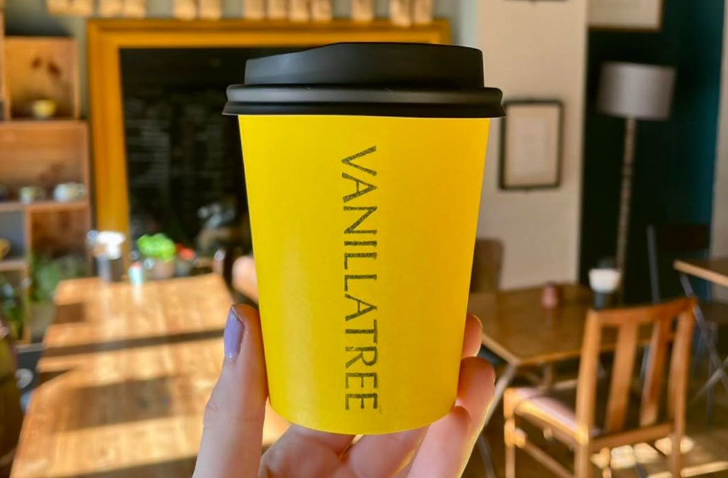 Coffee to go at Vanilla Tree is served in their signature bright yellow coffee cups