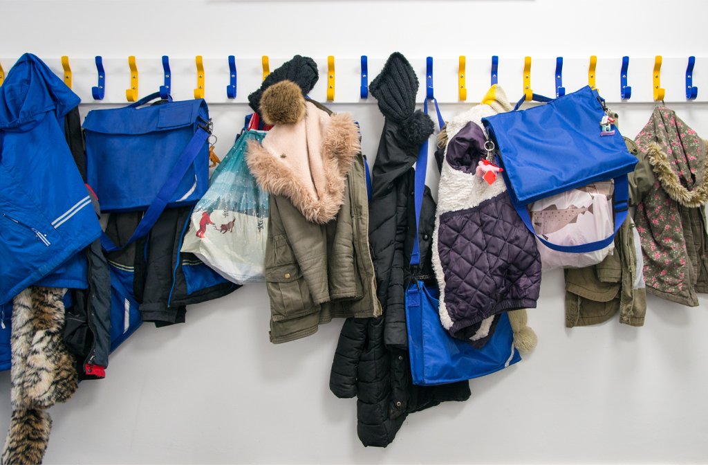 A row of children's coats on a coat wrack at a primary school