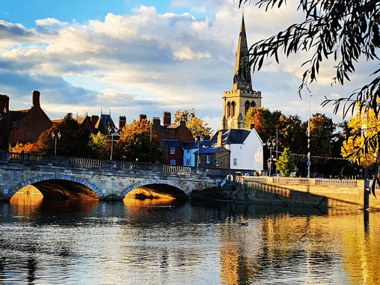 Town Bridge, the River Great Ouse and the spire of St Paul's church in dappled sunlight