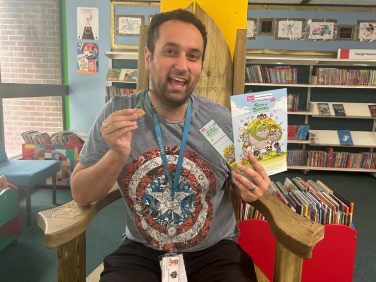 Bedford Central library employee holding a copy of 'The Story Garden'