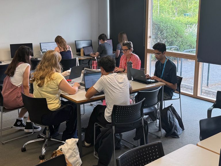 Kimberley College students sitting at computers and desks, taking part in Progress Publishing's newsroom work experience week 2025. Image: Bedford Independent