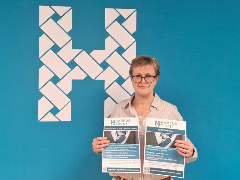 Lucy Bardner of the Harpur Trust holding leaflets about their school uniform initiative