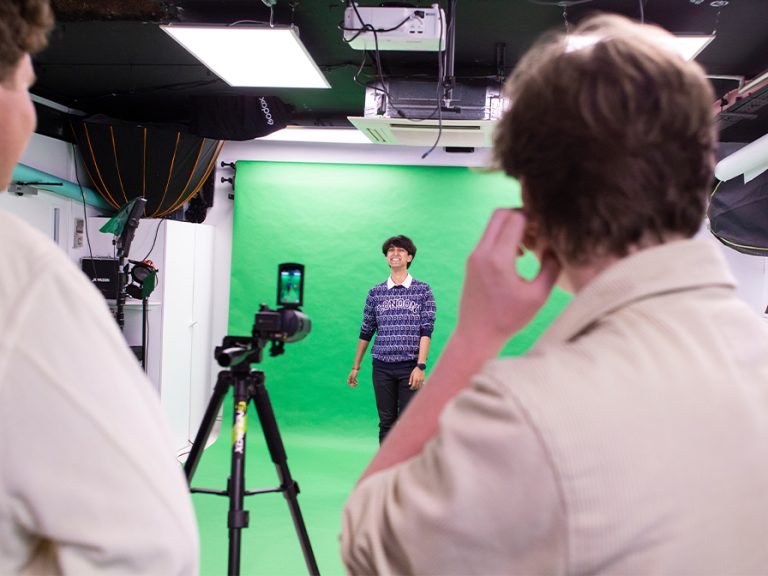 Youth TV presenter infront of a green screen during filming