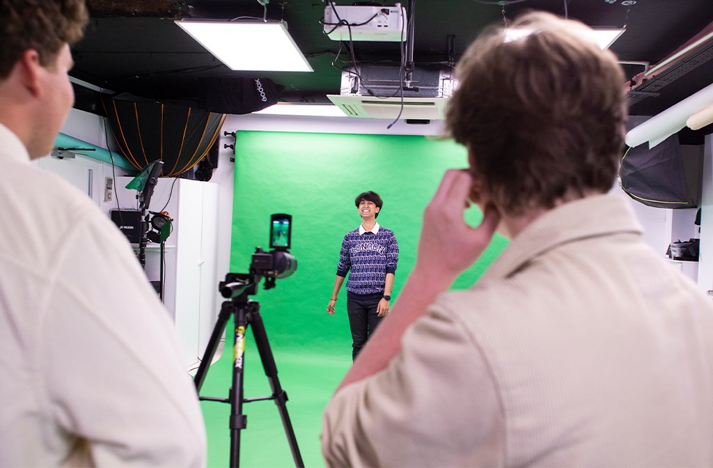 Youth TV presenter infront of a green screen during filming