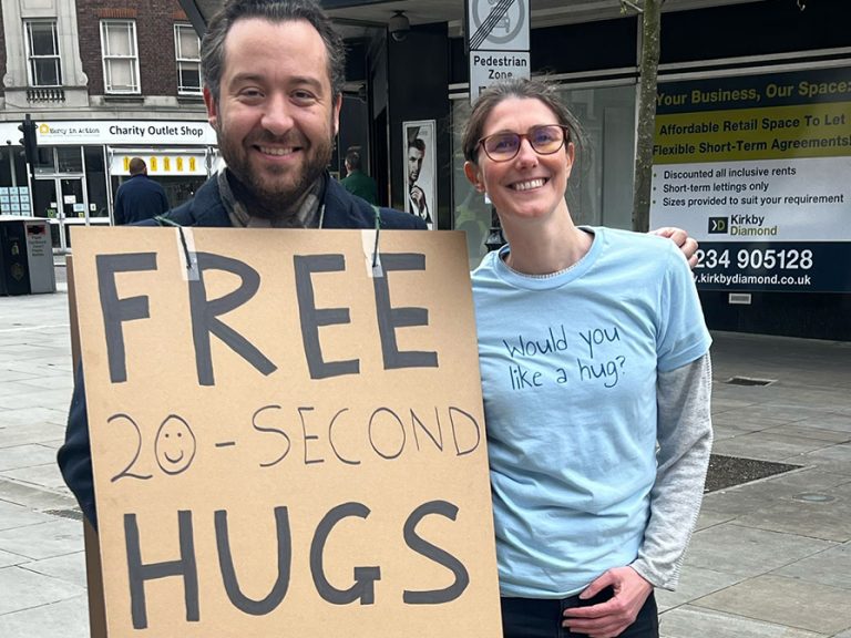 Team cuddle! (l-r) Pep Valerio with Cuddle Therapist Samii Wood in Bedford Town Centre. Image: Conscious Connected Touch