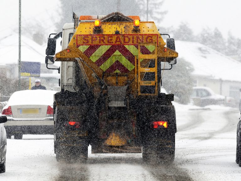 A gritter lorry spreading salt on a road in the winter snow. Image: Dimension Photos/Shutterstock