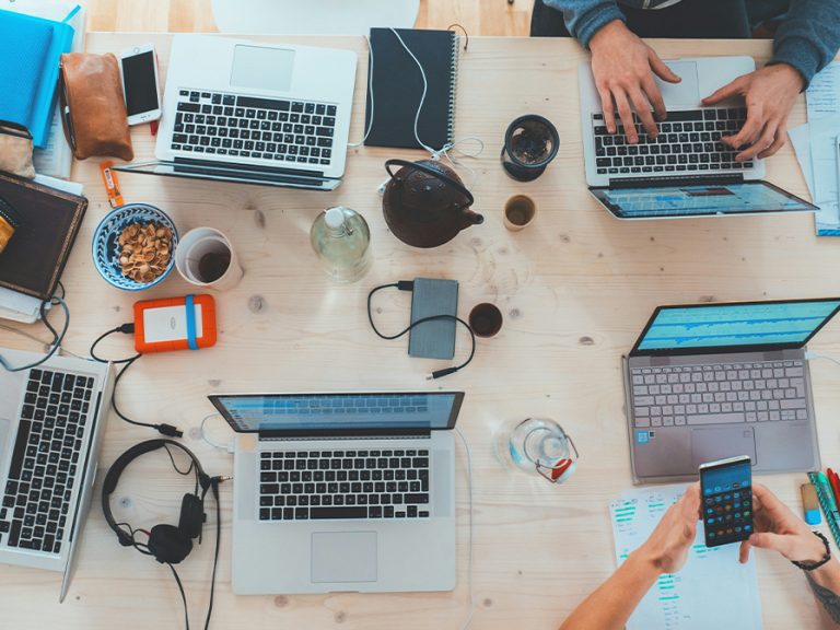 A shot from above of a table with laptops and other tech in a co-working space Image Marvin Meyer unsplash