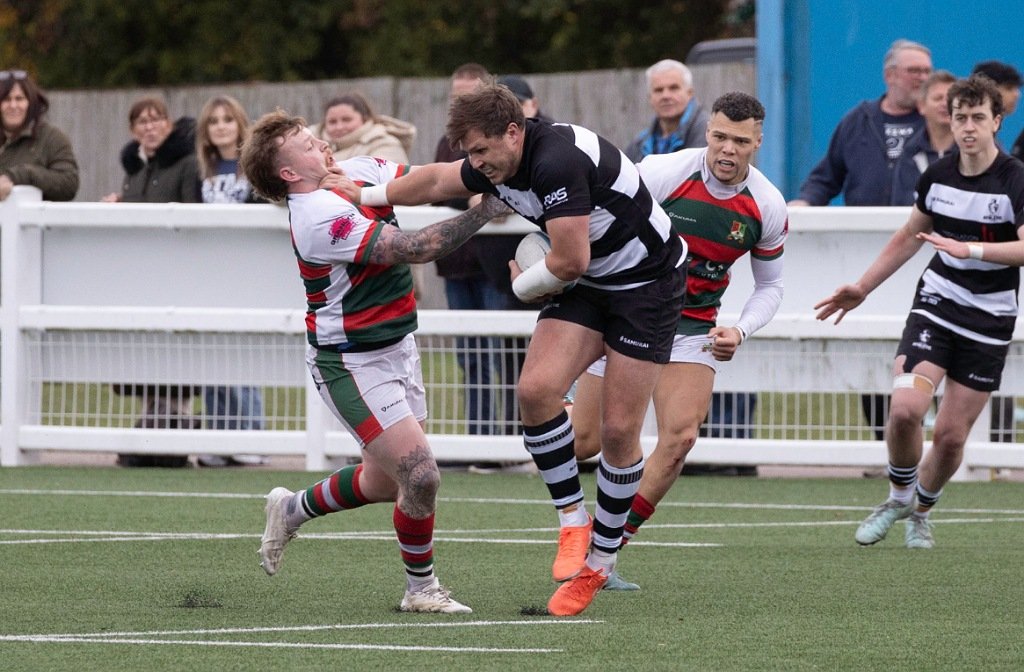 Bedford Athletic forward palms off a Broadstreet tackle in their clash in October 2025