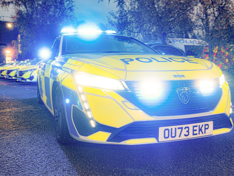 Bedfordshire Police patrol car at dusk with lights on Image Bedfordshire Police
