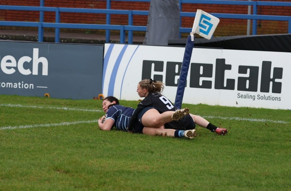 A Bedford Blues Women's player is tackled by a Harpenden defender in January 2026