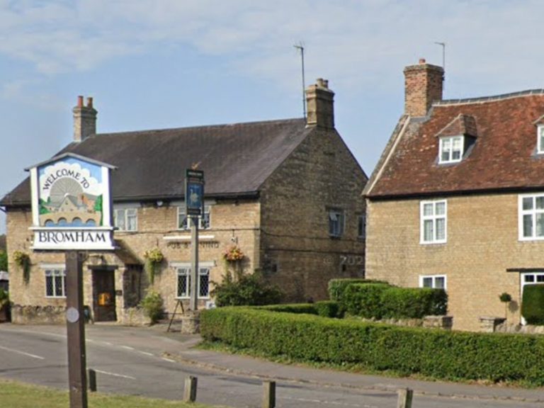 Bromham village sign with the Swan pub in the background.