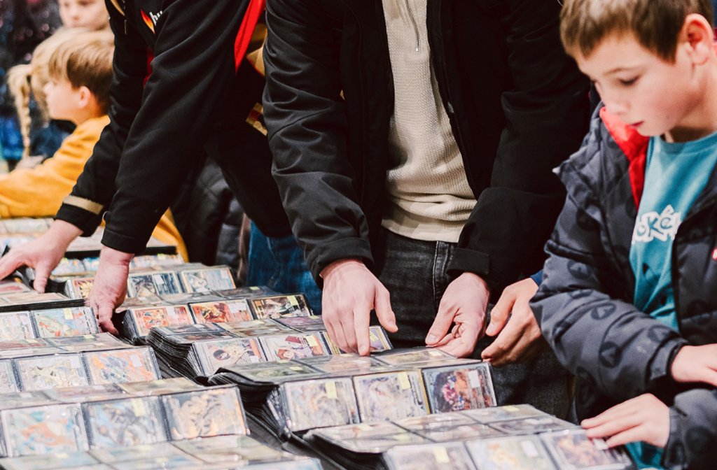 A young boy looks through displays of collectable cards including Pokemon