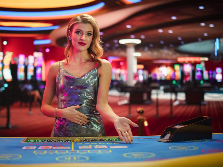 Croupier inviting somone to sit at a cards table at a casino Image Kitreel Shutterstock