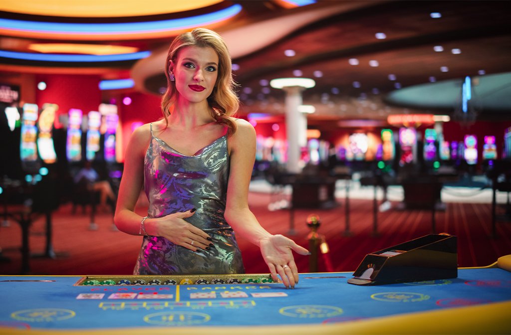 Croupier inviting somone to sit at a cards table at a casino Image Kitreel Shutterstock