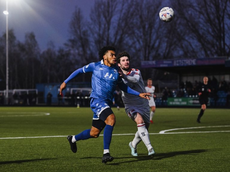 Bedford Town's Callum Ebanks takes on an AFC Fylde defender at The Eyrie