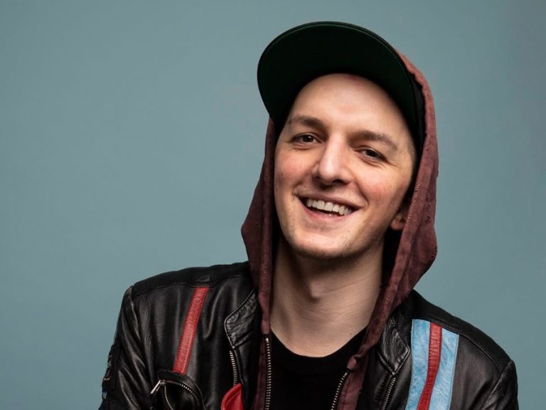 A headshot of Eddie Adams wearing a hoodie and cap