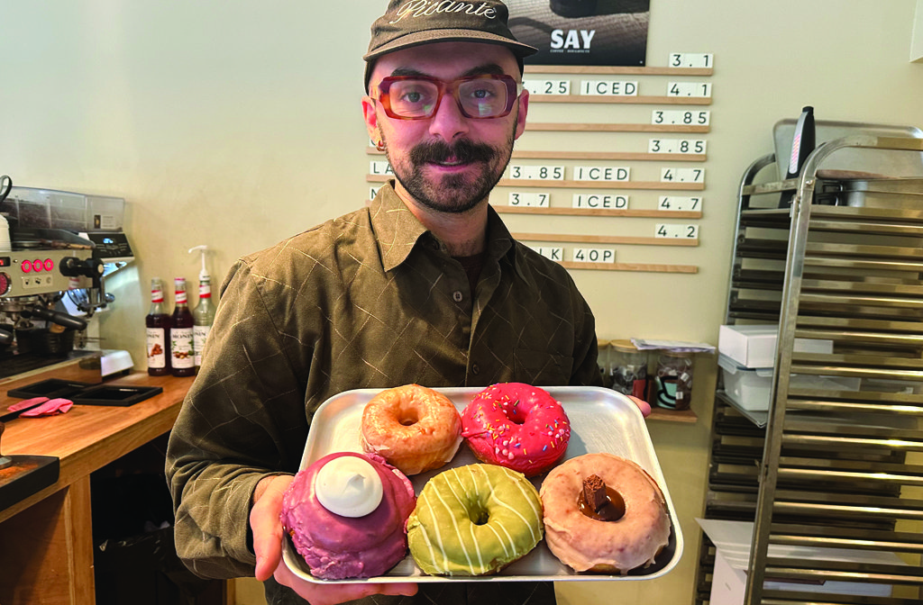Giacomo holding a tray of five doughnuts at SAY Doughnuts