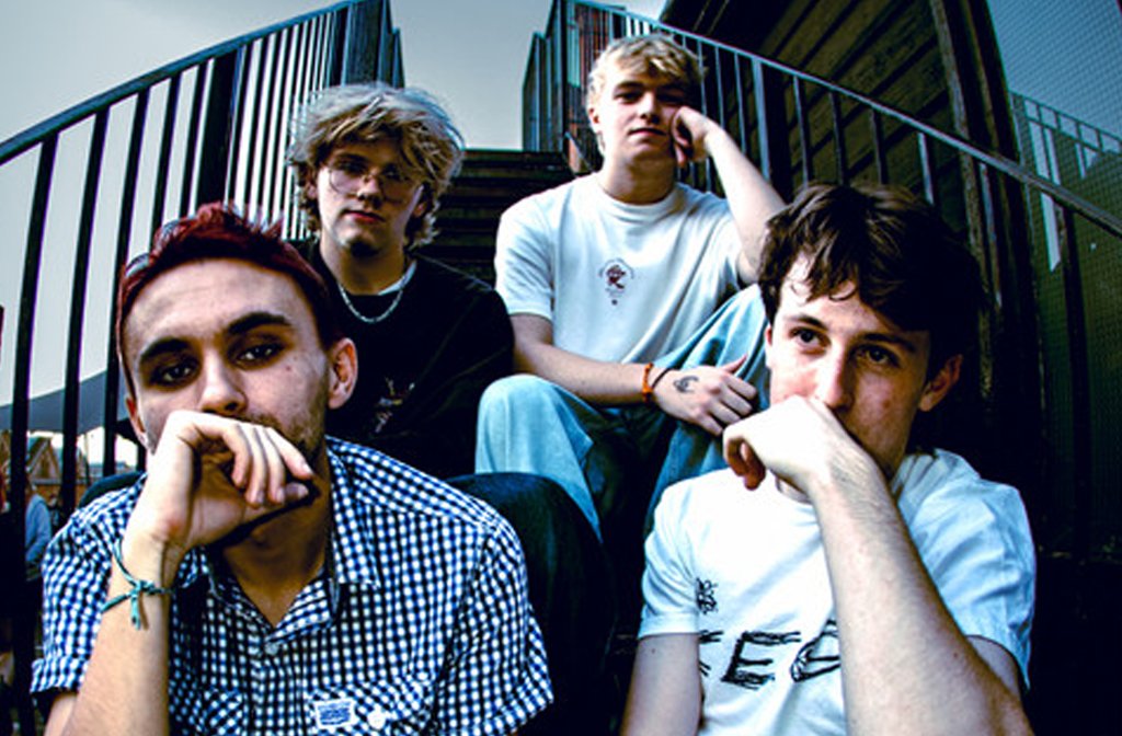 The four members of the band Greensands sitting on a metal staircase