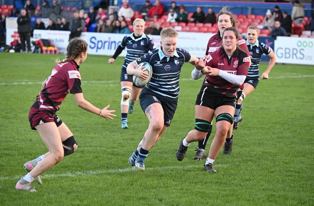 A Bedford Blues Women's player gets away from two Hitchin defenders at Goldington Road in November 2025