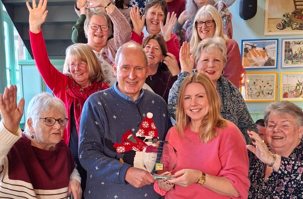 Lemon & Ginger - Knit, Crochet, Sew are presented with their Adult Tree Trophy by Nick Kier of Lane & Holmes Estate Agents surrounded by members of the Christmas Tree Festival Committee. Image: Bedford Christmas Tree Festival