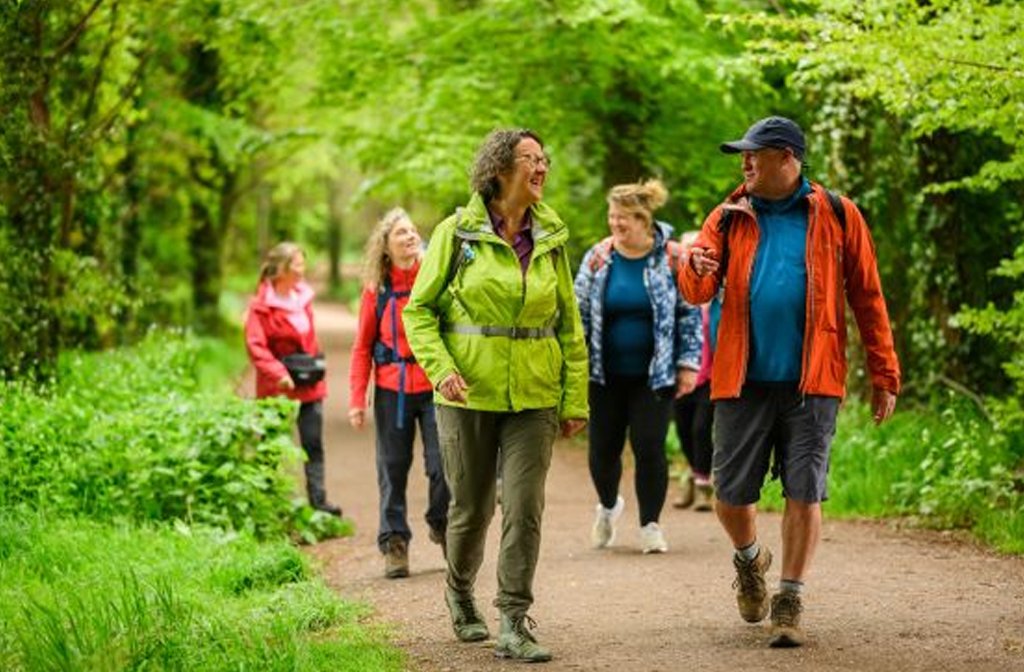 Members of the North Beds Ramblers group walking through a leafy forest