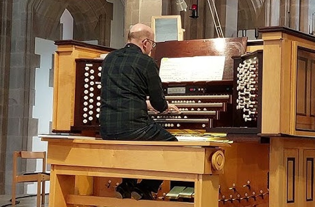 Organist Laurence Caldecote sitting at a church organ