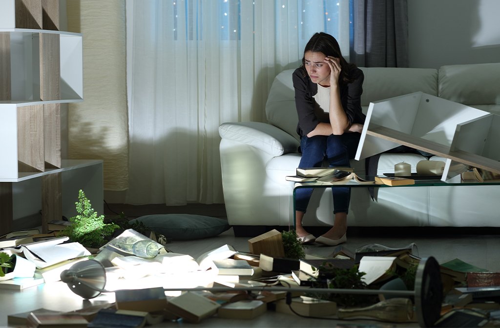 Sad woman alone in the night after robbery sitting on a couch at home Image Pheelings media Shutterstock